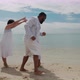 A mixed-race family having fun playing together on the beach on the tropical beach on vacation. - VideoHive Item for Sale