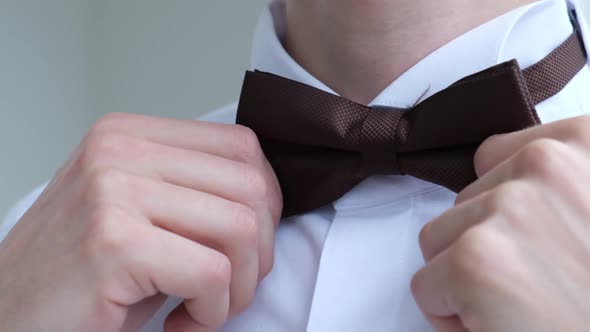 Man Straightens a Bow Tie Close Up Slow Motion