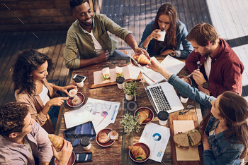 Shot of a group of creative workers having a meeting over lunch in a cafe