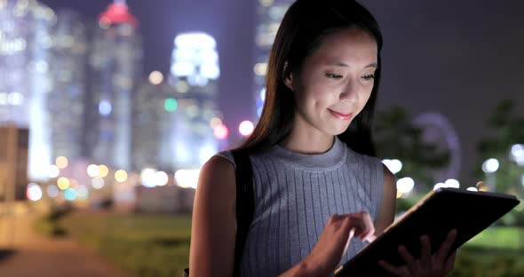 Woman Using Tablet Computer in Hong Kong City at Night 