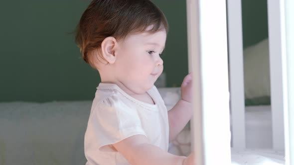 Portrait of Curious Child at Home Little Caucasian Baby Girl Looks Into Camera Happy Childhood Games