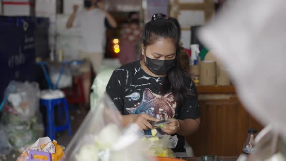 Female Vendor In Mask Preparing Fresh Flower Petals For Sale At The Stall In Pak Khlong Talat