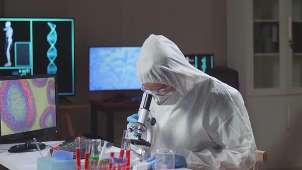 Asian Doctor In Protective Suit Working On Computer In A Modern Lab
