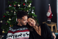 smiling couple cuddling on the sofa at home at christmas time - PhotoDune Item for Sale