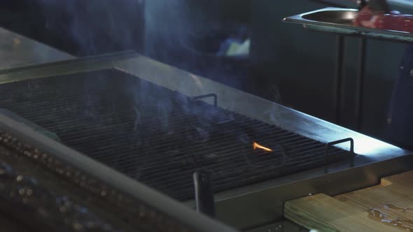 Cropped Shot f a Chef Grilling Steak on the Restaurant Kitchen