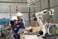 Robotics engineer operating robot aided CNC machine in robotics research facility - PhotoDune Item for Sale