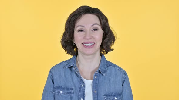 Old Woman Smiling at the Camera, Yellow Background 