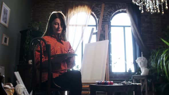 A Young Pretty Woman in Art Workshop Mixing Shades on a Palette