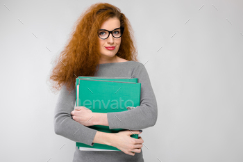 ess and eyeglasses isolated on grey background holding big folder with files graduate or course work report relief concept.
