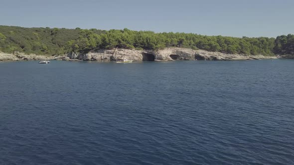 Rocky Coastline With Caves And Boats. View From Fast Boat. Flat Color