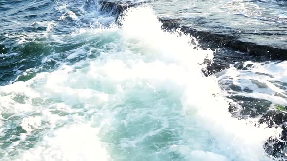 Wave breaking on rocks. Big waves crash into the rocks