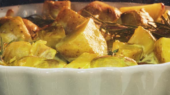 Sliced potatoes are baked in sour cream on a dish in a home kitchen oven, close-up