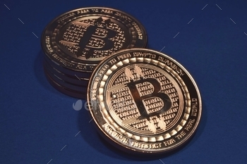 Closeup of bitcoins under the lights against a blue background