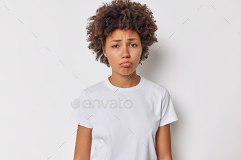  gross or pity grimaces displeased frowns upset dressed in casual t shirt isolated over white background thinks about something troublesome.