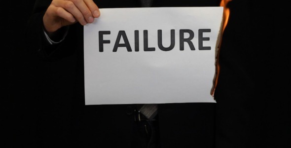 Businessman Burning Failure sign