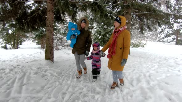 Young parents walking with their children in winter Park