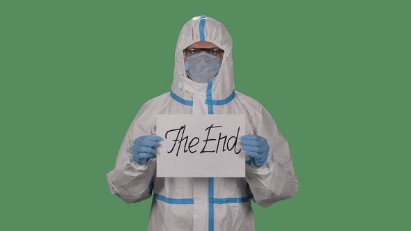 Portrait of a Man in a Protective Suit, Goggles, Gloves and a Respirator Looking at the Camera