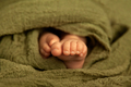 Newborn baby feet in a green wrap at natural light, closeup of tiny toes, indoor photography - PhotoDune Item for Sale