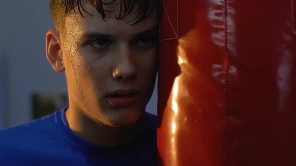 Tired Teenage Boxer Looking Camera Standing Near Punching Bag, Sport Will Power