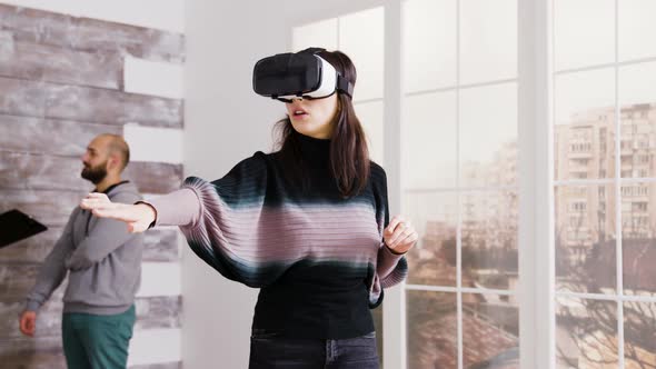 Female Architect Using Virtual Reality Goggles in Empty Apartment