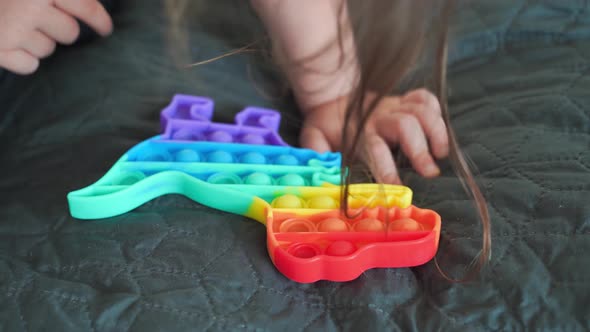 Toddler Girl with Popit Toy in Rainbow Colours