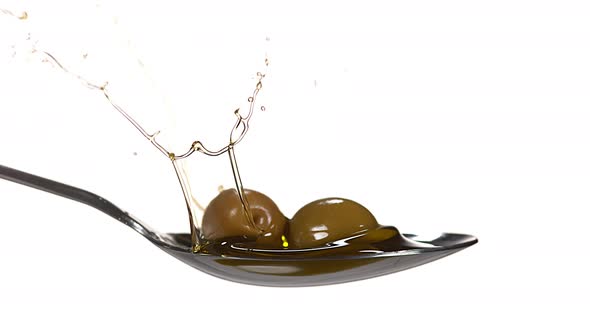 Olive Falling into Olive Oil against White Background, Slow Motion 4K