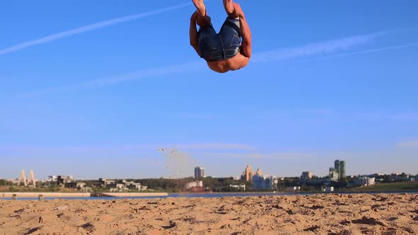 Young Man Doing Push Ups on the Beach Sand and Performing Somersaults