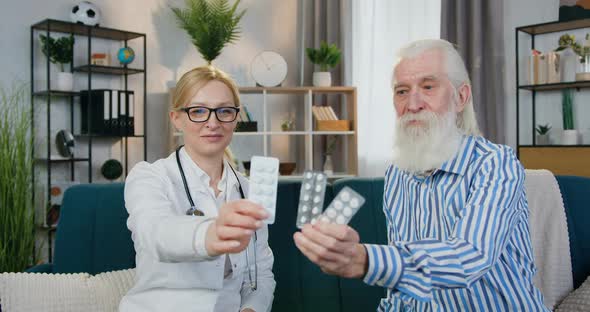 Doctor and Her Male Patient which Sitting on the Couch and Presenting Pills Into Camera