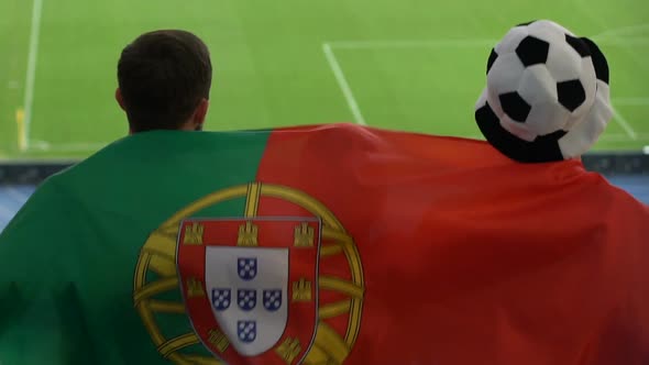 Football Fans With Portuguese Flag Jumping and Watching Game at Stadium, Slow-Mo