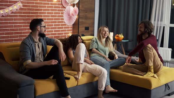 Four People in Living Room on Sofa Together Having Fun Fighting