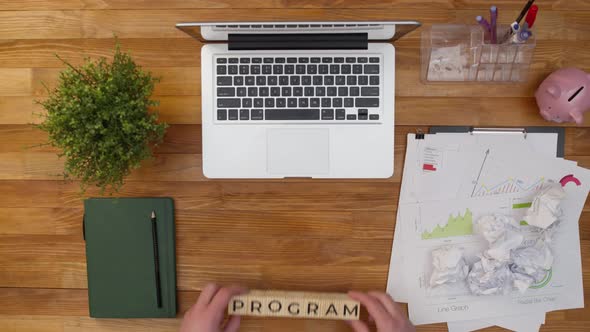 Word Program is Collected From Wooden Cubes in the Workplace Next to a Laptop and Work Papers