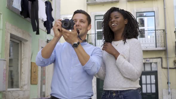 Positive Joyful Mix Raced Couple of Tourists Taking Photos