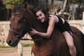 Amazon girl in black dress hugging her horse. - PhotoDune Item for Sale