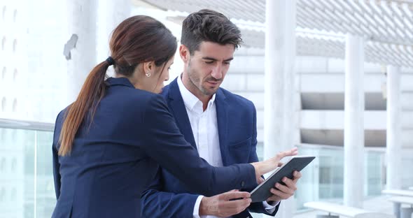 Business people discuss on tablet computer