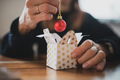Closeup view of a woman placing shiny red holiday bauble in a small christmas giftbox - PhotoDune Item for Sale