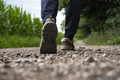 Low angle view of a sole of a man in hiking shoes walking on a gravel road - PhotoDune Item for Sale