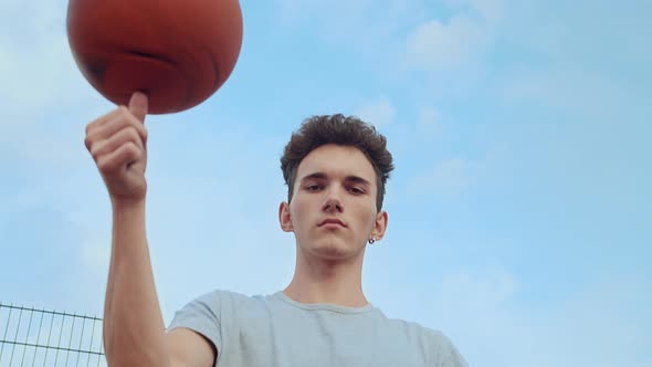 Portrait of a Young Guy with a Basketball Spinning a Ball