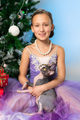 Girl 9 years old in purple dress holding purebred Sphynx Cat sits near Xmas tree on New Year's Eve. - PhotoDune Item for Sale