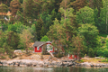 Sweden. Beautiful Red ASwedish Wooden Log Cabins Houses On Rocky Island Coast In Summer. Lake Or - PhotoDune Item for Sale
