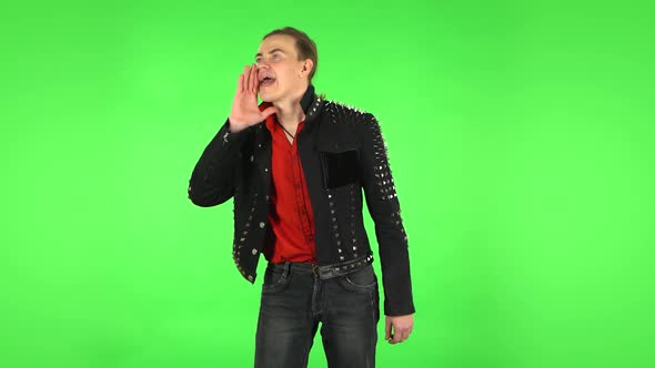 Guy Screams Calling Someone on a Green Screen at Studio. Green Screen