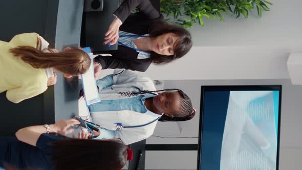 Vertical Video Secretary Working at Busy Hospital Reception Desk to Help Patients