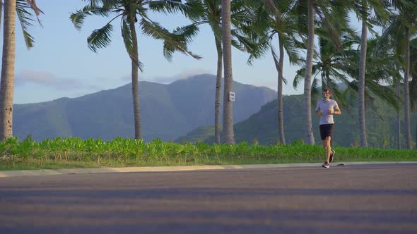 A Man Wearing a Face Mask is Running on a Street in a Tropical Surrounding