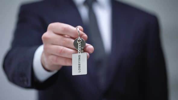 Lobbying Word on Keychain in Businessman Hand, Illegal Protection of Interests