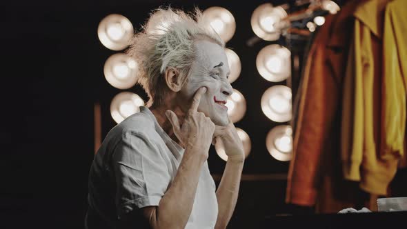 Clown Sits Against Mirror Practicing Acting for Performance