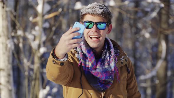 Happy Handsome Man Throwing Snow Up in Front of Camera