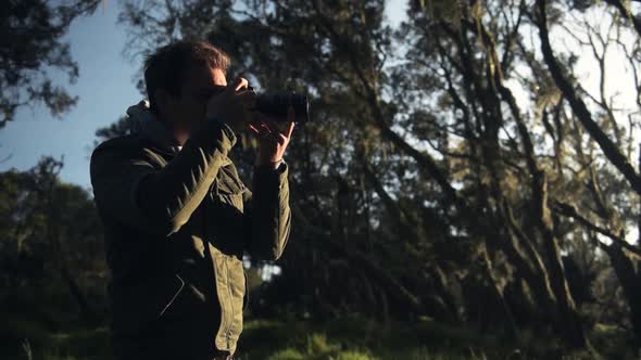 A Man In A Jacket Taking A Picture In The Wilderness In Aberdare National Park In Kenya. -medium sho