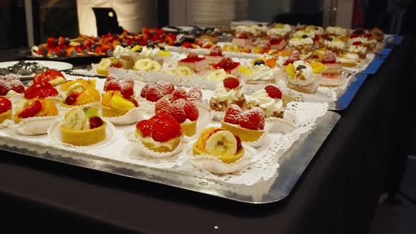 Dessert buffet with sweets. Delicious fruitcakes on table trays waiting to be eaten