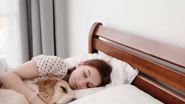 Girl with Golden Retriever Dog in the Bed