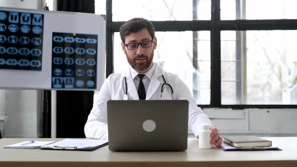 Pleasant Proud Caucasian General Doctor Conducts Online Consultations Communicates with the Patient