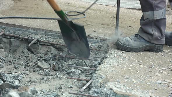 A Worker Repairs the Road Surface with a Jackhammer on a Summer Day